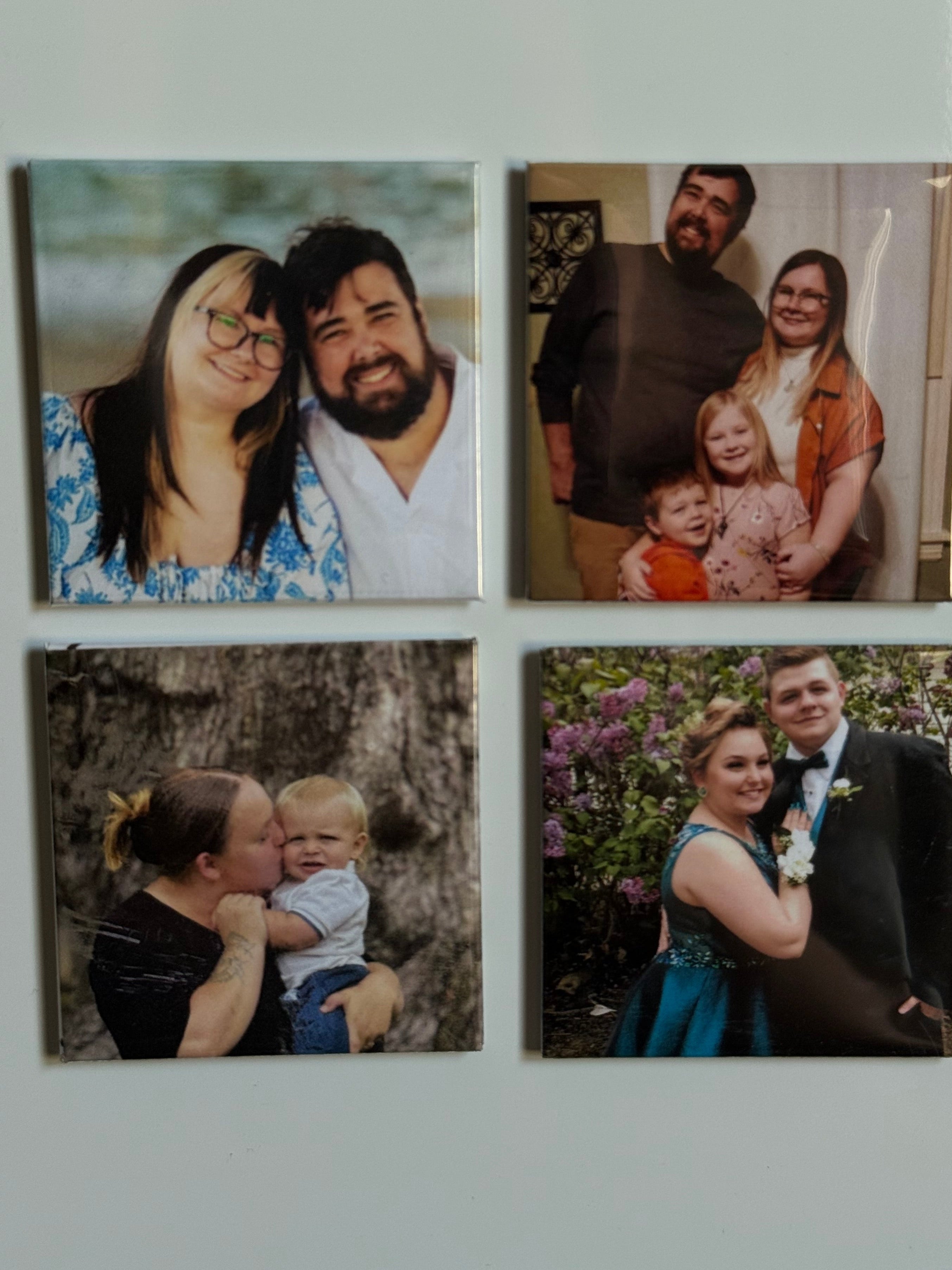 Four photo frames on a wall with family and couple photos.